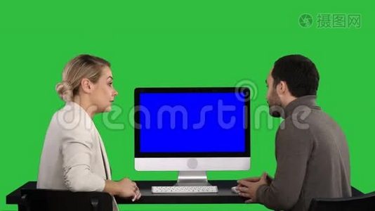 商务人士在电脑显示器周围开会，谈论绿色屏幕上屏幕上的内容，Chroma视频