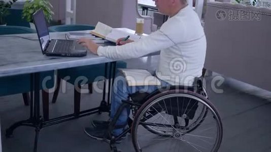 残疾、成功患病学生的远程教育，男性坐在轮椅上，用手提电脑从网上学习视频
