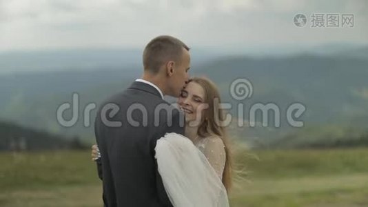 新郎新娘在山上玩得开心。 新婚夫妇拥抱视频