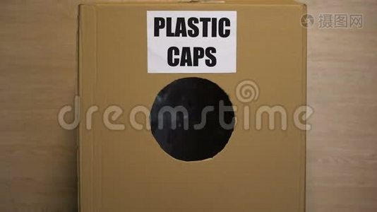 女士在纸板箱里扔塑料帽，收集可重复使用的材料视频