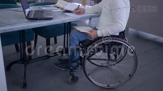 在网上教育的远程学习过程中，轮椅上的成功患病学生在手提电脑上工作视频