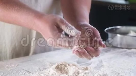 面包师傅用面粉拍了几次手。 洗手。 小麦粉把灰尘飞过桌子. 慢动作特写..视频