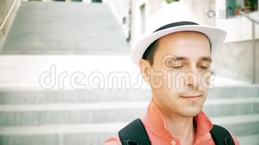 戴着帽子的男旅行者走在楼下的街道上视频