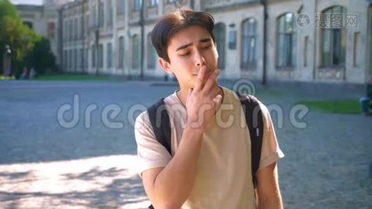 可爱的亚洲男人用手指在嘴唇上思考，上下打量视频