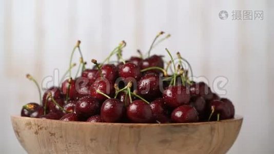 新鲜的，成熟的，多汁的樱桃放在一个木碗里，可以旋转。食物背景。美食概念，有机食品。视频