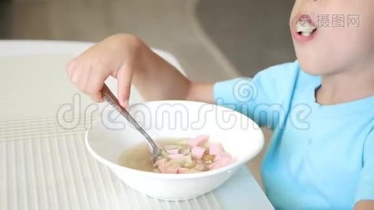 孩子坐在厨房的桌子旁，吃汤特写.. 健康宝宝食品的概念..视频