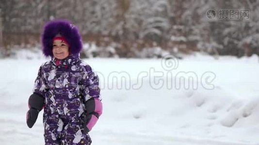 快乐的孩子在冬天的第一场雪中玩耍。 冬暖夏凉的小男孩穿着温暖的雪服走路，玩得开心视频