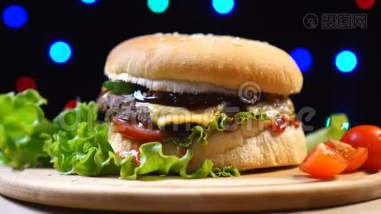 自制和新鲜美味的汉堡与奶酪，番茄，生菜在彩色模糊的背景视频