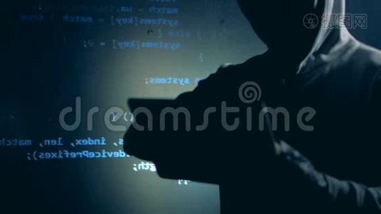 伪装的男黑客穿着帽衫和电脑数据投影视频