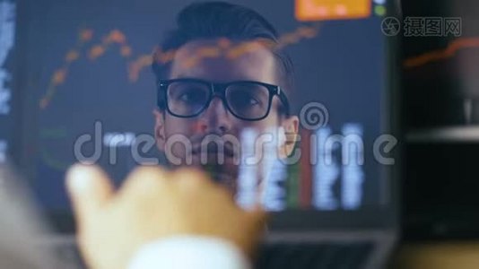 双曝光：戴眼镜的人在笔记本电脑上工作，检查股票市场。 《班长反思：成功》视频