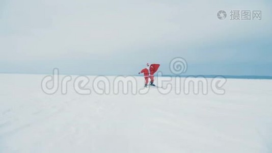 一个圣诞老人拿着一个带礼物的包滑雪，特写。视频