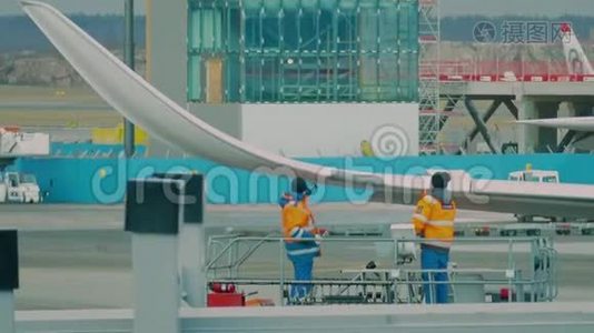两名技术专家在机场修理飞机机翼视频