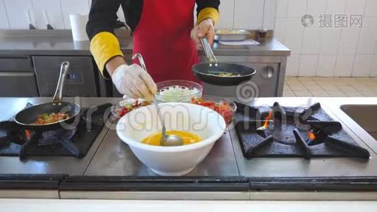 不可识别的厨师烹饪美味的素食菜肴在现代厨房的餐厅。 男性厨师加入平底锅配料视频