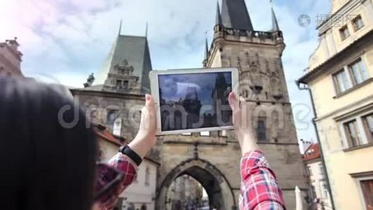 女旅行者用平板电脑拍摄中世纪城堡和蓝天的照片视频