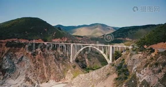 惊人的空中拍摄比克斯比峡谷大桥在1号高速公路在大南加州美国，史诗自然天际线背景拍摄。视频