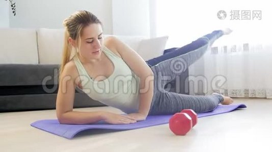 年轻女子在家做健身运动后在瑜伽垫上伸展身体的4k镜头视频