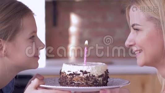 生日快乐妈妈，小妈妈带着小女孩在节日蛋糕上吹蜡烛，微笑着互相看着视频