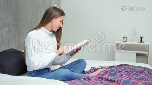 摘要：年轻女学生阅读教科书，并在家中的床上微笑全镜头视频