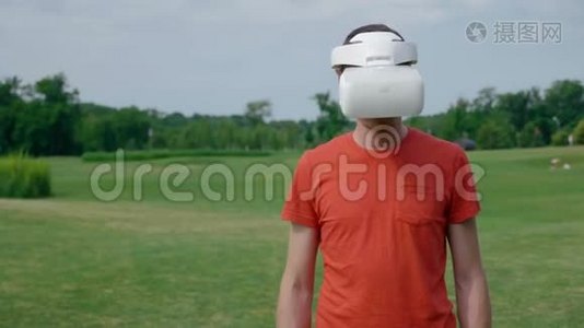 一个男人在公园里用VR耳机把头低下来视频