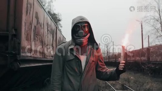 戴防毒面具的人穿过废弃的火车站拿着信号火视频