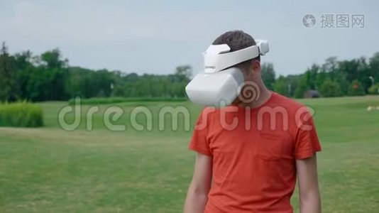 一个男人在公园里用VR耳机把头低下来视频