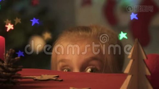 小女孩从桌子底下出现，四处张望，做圣诞恶作剧视频