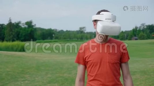 一个男人在公园里用VR耳机把头低下来视频