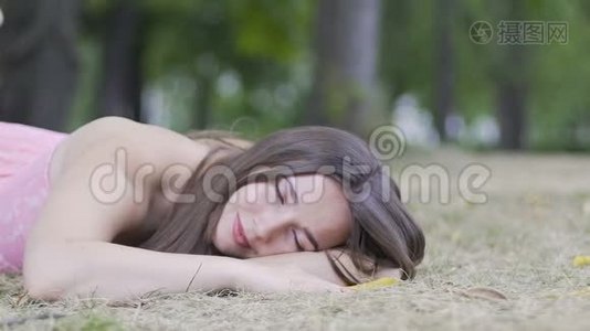 放松的美丽躺着的女人在镜头中睁开眼睛，在室外拍摄视频