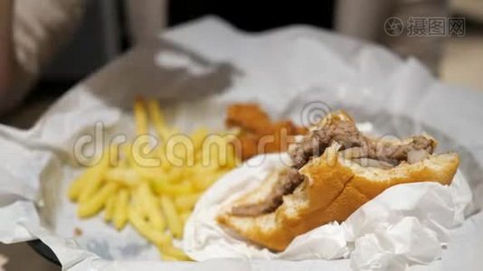女人吃薯条，鸡肉和汉堡在快餐店，食品特写。视频
