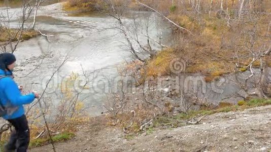 带背包的旅行者在路上。 他走近山涧，借助特殊的木棍传球视频