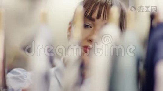 一个女人从衣服后面看着一家服装店的货架视频