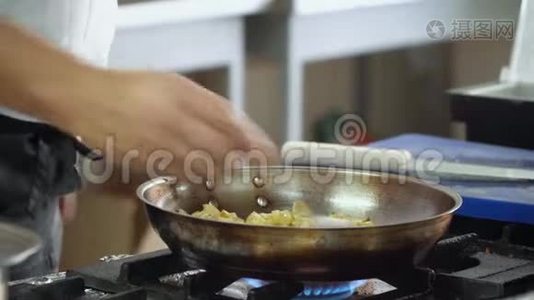 厨师把洋葱和腌制的蘑菇混合在煎锅里。 手的特写动作视频