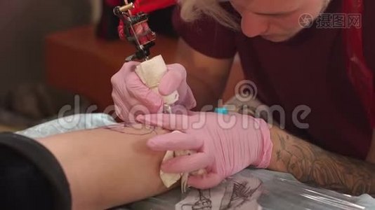 在纹身工作室做纹身的师傅。 男人在女孩腿上做纹身视频