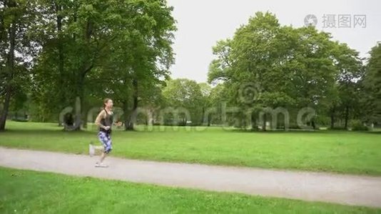绿色公园里跑步的女青年视频