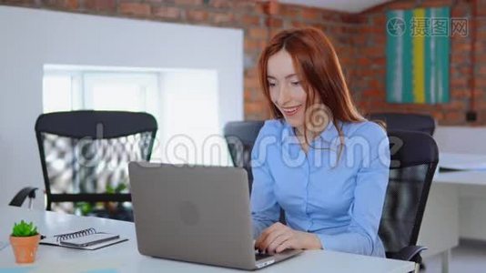 兴奋的女商人享受办公室笔记本电脑屏幕上的好消息视频