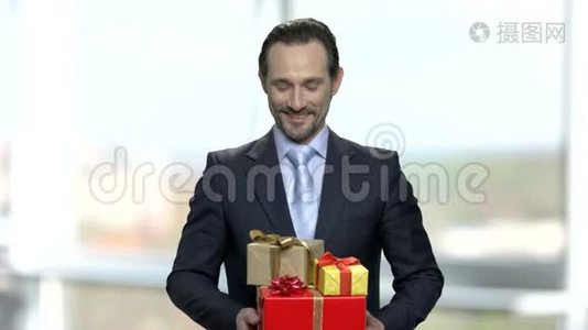 微笑的男人带着一群礼物盒。视频