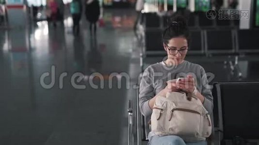 女孩在机场休息室使用智能手机视频