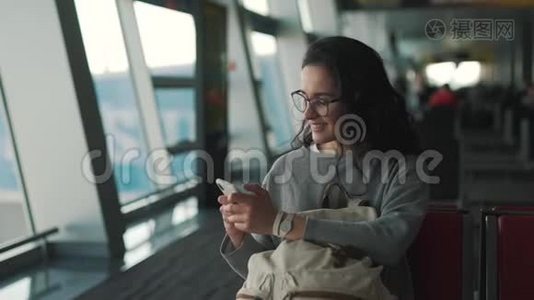 女孩在机场休息室使用智能手机视频