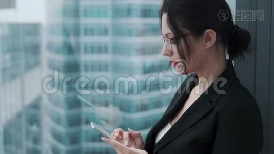 现代建筑背景下一位手拿手机的女商人的画像视频