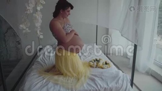 美丽的孕妇抚摸她的腹部。 女人摸她的肚子。 慢动作视频