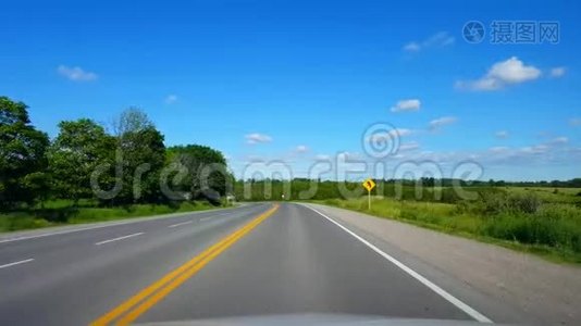 在晴朗的夏日，沿着森林行驶乡村道路。 司机观点POV美丽的卢什绿叶视频