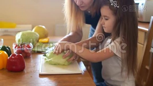 妈妈和厨房里的小女儿切白菜做素食沙拉.. 妈妈`帮手视频