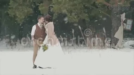 一对爱不释手的情侣站在白雪皑皑的冬季公园里视频