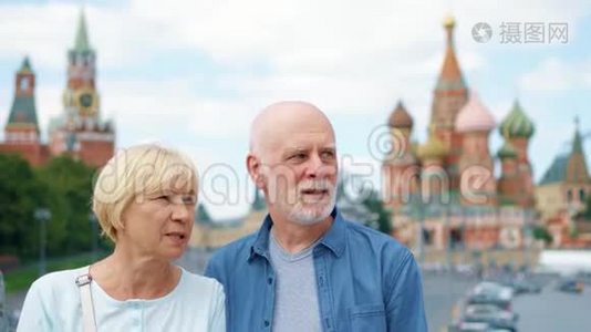 老两口站在Basil`的后裔环顾城市。 在俄罗斯莫斯科旅行的养老金领取者视频