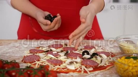 年轻女孩把橄榄片撒在家里准备的披萨上视频