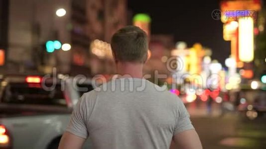 夜间拍摄唐人街街道照片的年轻游客的后景视频