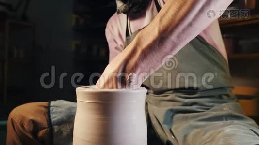经验丰富的陶工用陶制工具塑造陶罐. 紧紧抓住在陶工`车轮上工作的男性双手视频