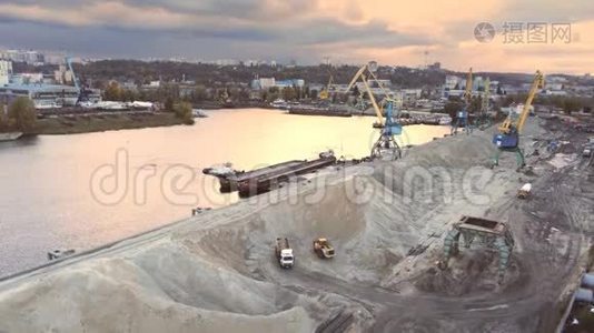 傍晚日落时分，基辅第聂伯河货运码头重型起重机装载散装货物的鸟瞰图视频