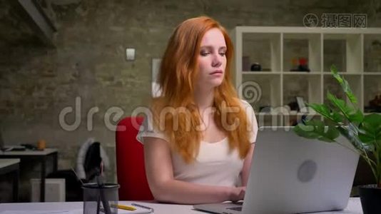 美丽的白种人女性坐在笔记本电脑上打字，姜发，工作氛围，室内，光线办公室视频