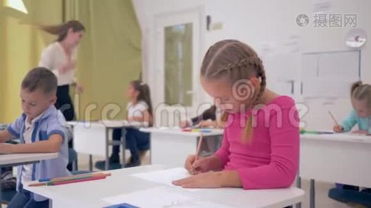 小女生坐在课桌后面，以同学为背景，在光线教室里上课。视频